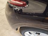 a black car that has been dented and is parked in a garage