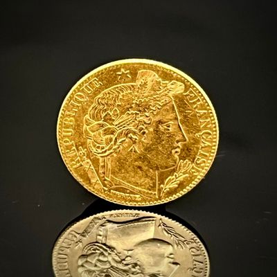 une pièce d'or et une pièce d'argent posées sur une surface noire