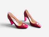 a pair of red high heeled shoes on a white surface