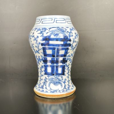 un vase bleu et blanc posé sur une table noire