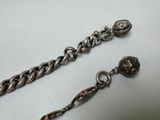 a close up of a silver chain with a skull on it