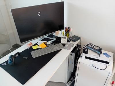 un bureau d'ordinateur équipé d'un clavier, d'une souris, d'un tapis de souris et d'un écran