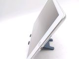 a tablet computer sitting on a stand on a white surface