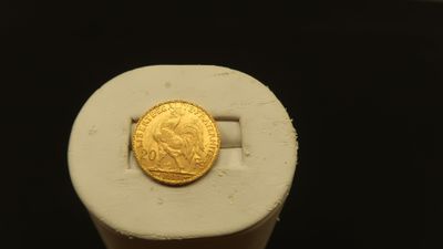 a gold coin sitting on top of a white object
