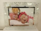 a picture of a baby in a picture frame with a teddy bear