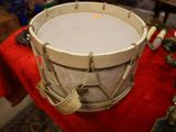 a drum sitting on a table with a red cloth