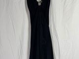 une robe noire suspendue à un cintre sur un drap blanc