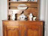 a wooden cabinet with many plates on top of it