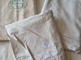 trois serviettes blanches monogrammées sont posées sur un lit