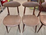 three brown chairs sitting on top of a floor next to a shelf