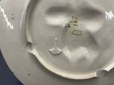 a white plate with a bird on it on a table