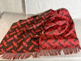 une écharpe rouge et noire posée sur un canapé blanc, avec une chaise blanche en arrière-plan