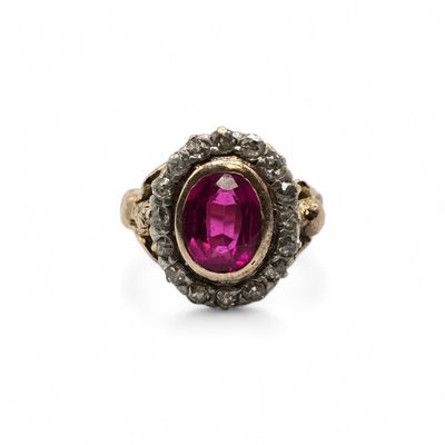 a close up of a ring with a pink stone surrounded by black diamonds