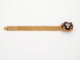 un bracelet en or orné d'une fleur noire et blanche