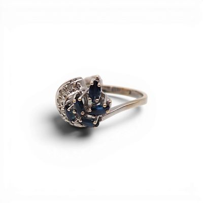 une image d'une bague en diamant et saphir sur fond blanc