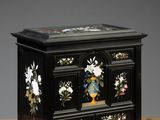 une image représentant une boîte en bois noire ornée de fleurs