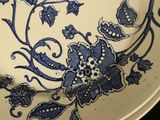 a blue and white plate with a flower design on it
