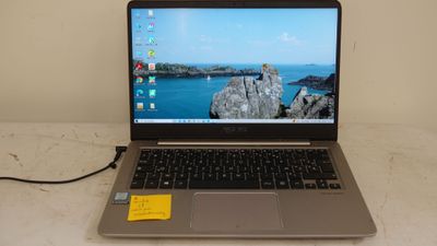 a laptop computer sitting on a table with a yellow sticker on it