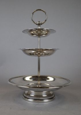 a silver three tiered cake stand on a table