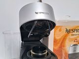 a coffee maker sitting on a table next to a glass of water