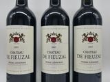 trois bouteilles de vin posées sur une table blanche
