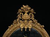 a gold mirror with a clock in the middle of it