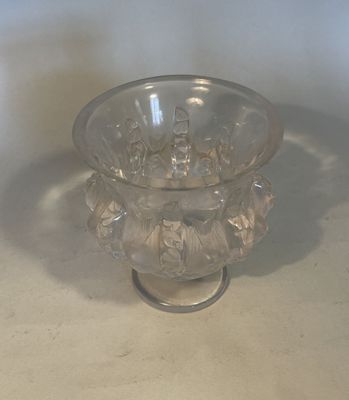 a clear glass bowl with a handle on a table