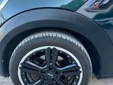 un gros plan d'une Mini Cooper verte garée sur un parking