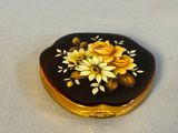 une boîte noire et dorée ornée de fleurs jaunes
