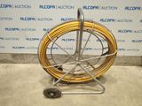 an image of a hose on a cart in front of a wall
