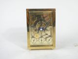 a gold clock with a blue face on a white background