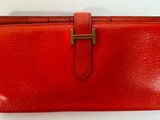 un portefeuille en cuir rouge muni d'un fermoir doré
