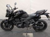 a picture of a black motorcycle parked on a checkered floor