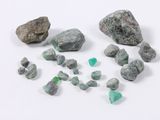 several pieces of green and white rocks and stones on a white surface
