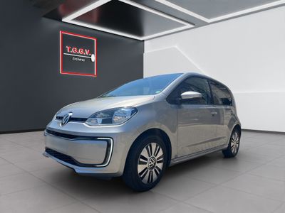 a silver volkswagen e - up parked in a showroom
