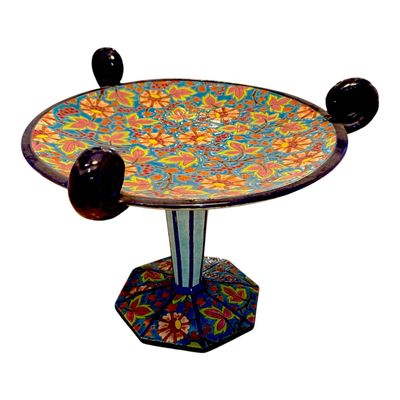 a colorful table with two black balls on top of it