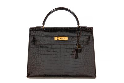 a black crocodile skin handbag with gold hardware on the handle