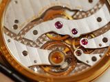 a close up of a watch on a white surface