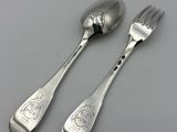 deux cuillères et une fourchette en argent sur une table
