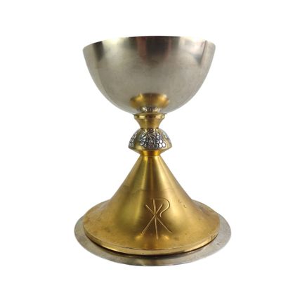 silver and gold chalicee with a cross on the base