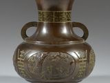 un vase marron orné d'un motif doré