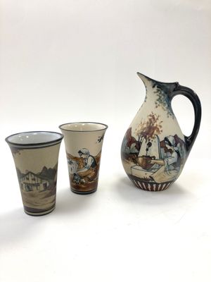 trois tasses et un pichet posés les uns à côté des autres sur une table