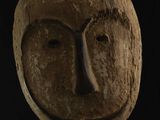 une image d'un masque en bois sur fond noir