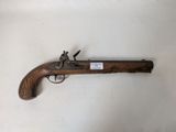 un gros plan d'un pistolet posé sur une surface blanche, sur lequel est accrochée une étiquette