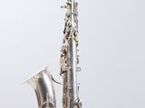 an image of a silver saxophone sitting on top of a white surface