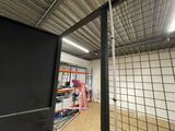 a room that has a metal fence and a ladder in it