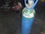 a blue propanent sitting in a garage next to a pair of shoes