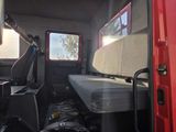an image of a red van with a bed in the back of it