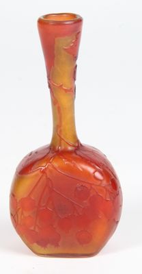 un vase rouge et jaune posé sur une surface blanche