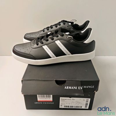 black and white adidas sneakers with white stripes on top of a box